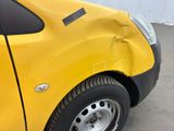 a yellow car that has a dent in the side of it