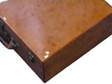 a brown suitcase that is sitting on a white surface