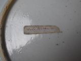 a label on a white plate with a brown border