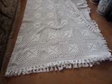 an image of a white crocheted rug on a wooden floor