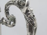 an image of a silver vase with a handle on a table