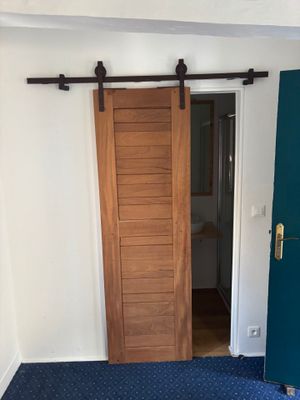 une pièce recouverte de moquette bleue, avec une porte et un sol recouvert de moquette bleue
