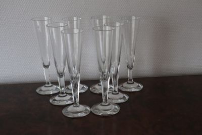 four empty wine glasses sitting on top of a table next to a wall