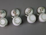 four cups and saucers are lined up on a gray surface