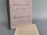un vieux livre posé sur une table à côté d'une feuille de papier