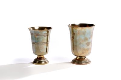 deux vases en argent posés l'un à côté de l'autre sur une surface blanche