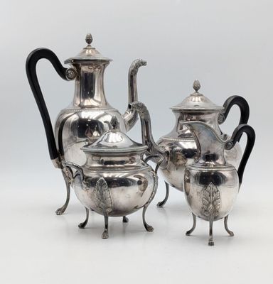 deux théières en argent et une cafetière posées sur un support