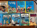 several children ' s french books on a table with a lamp