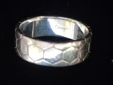 gros plan d'une bague en argent sur une surface noire
