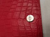 leather wallet with a button in the middle of it on a white surface