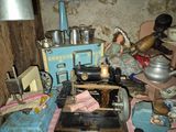 une poupée assise sur une machine à coudre dans une pièce