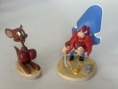 deux figurines représentant des insectes et une souris posées sur une table