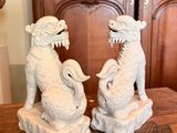 two statues of a dragon and a dog sitting on a table