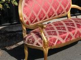 a red and gold couch sitting in the middle of the street