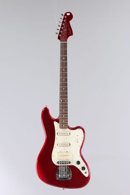 a red electric guitar hanging from a white wall