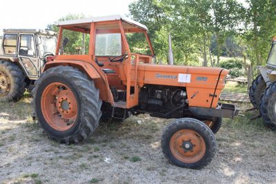 two tractors that are parked in the dirt