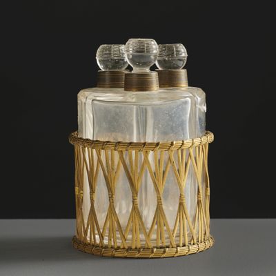 a glass jar with three bottles in it sitting on a table