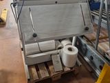Plusieurs rouleaux de papier toilette sont posés sur une palette dans un entrepôt