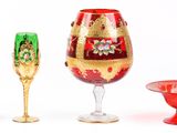 trois verres à vin et une coupe à vin posés sur une surface blanche