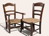 une paire de chaises en bois avec des assises tressées, sur fond blanc