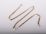 un ensemble composé d'un collier et d'un bracelet en or sur fond blanc