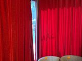 une photo d'un salon avec des rideaux rouges et un canapé