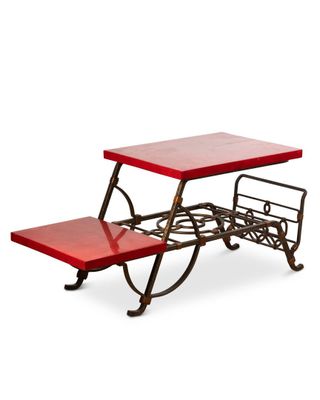 une image représentant une table rouge avec un banc en dessous