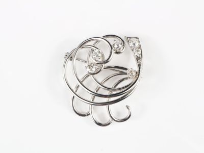 Broche tourbillon en or gris, sertie de diamants de taille a…