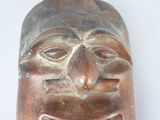 a wooden mask with a bow tie on it