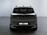 the rear view of a grey mercedes suv parked in a room