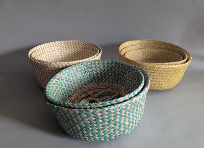 three woven baskets are lined up on a gray surface