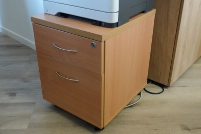 a printer sitting on top of a filing cabinet in a room