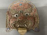 an image of a metal mask with red and blue decorations on it