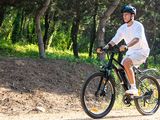 a man riding a bike down a dirt road