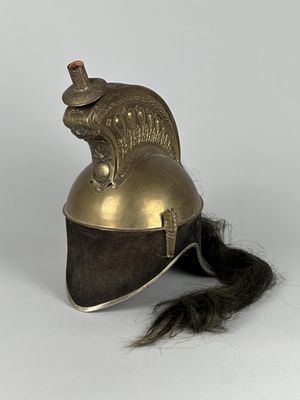 un gros plan d'un casque muni d'une longue queue, posé sur une surface blanche