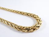 a close up of a gold necklace on a white surface