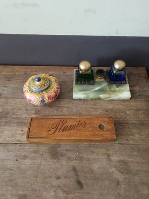 an old wooden table topped with two bottles of perfume and a wooden plaque