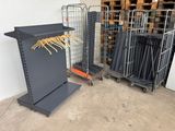 two metal racks with clothes hangers on them in a warehouse