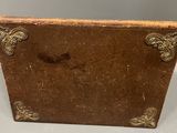 an old brown leather book with gold trim