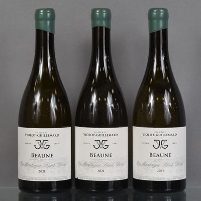 three bottles of wine are lined up on a table