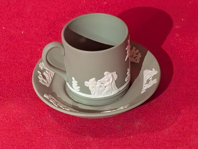 une tasse et une soucoupe posées sur une soucoupe, le tout sur une surface rouge