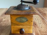 an old coffee grinder sitting on top of a wooden table