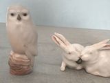 deux figurines d'animaux et un oiseau posés sur une table