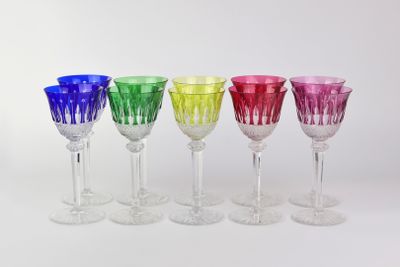 six different colored wine glasses in a row on a white surface