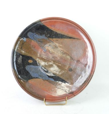 a plate with a painting on it on a white surface