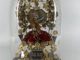 a glass dome with a clock inside of it on a table