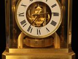 a gold clock with roman numerals on the face