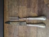 two knives that are on a wooden table