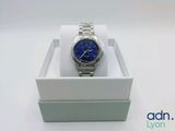 a close up of a watch in a box on a white surface