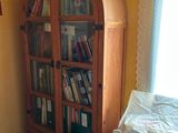 a bookcase with many books in it in the corner of a room